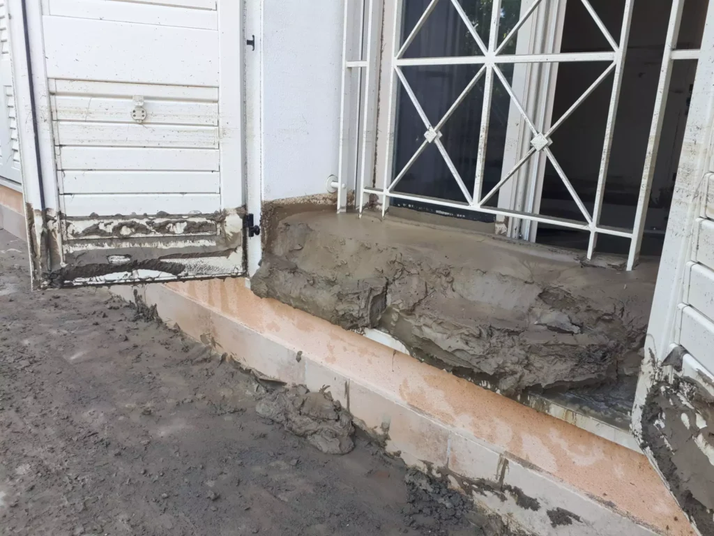 Entrata di una casa danneggiato da alluvione e con fango