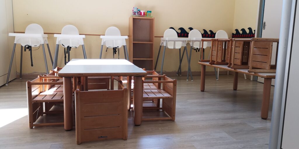 stanza di asilo per bambini con sedie e tavolini