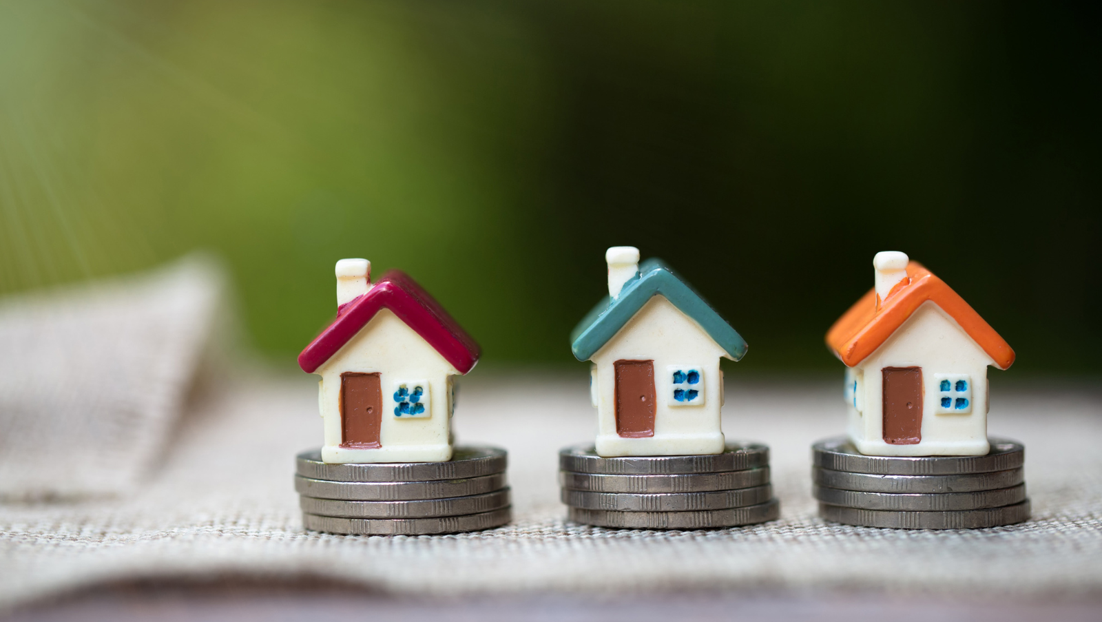 tre piccole case giocattolo con colori di tetti diversi